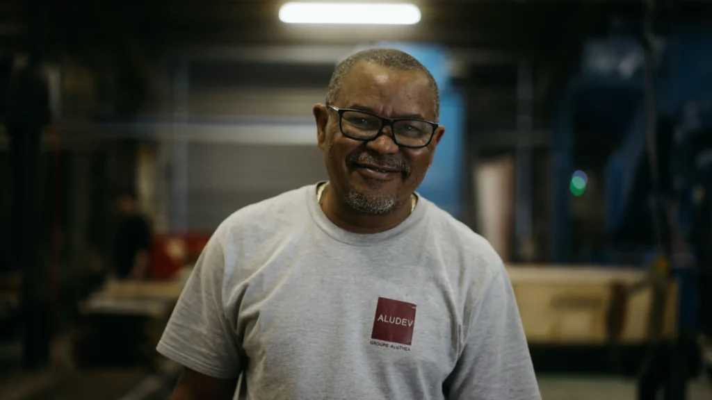 Portrait souriant d'un opérateur de la fonderie posant dans l'atelier de production