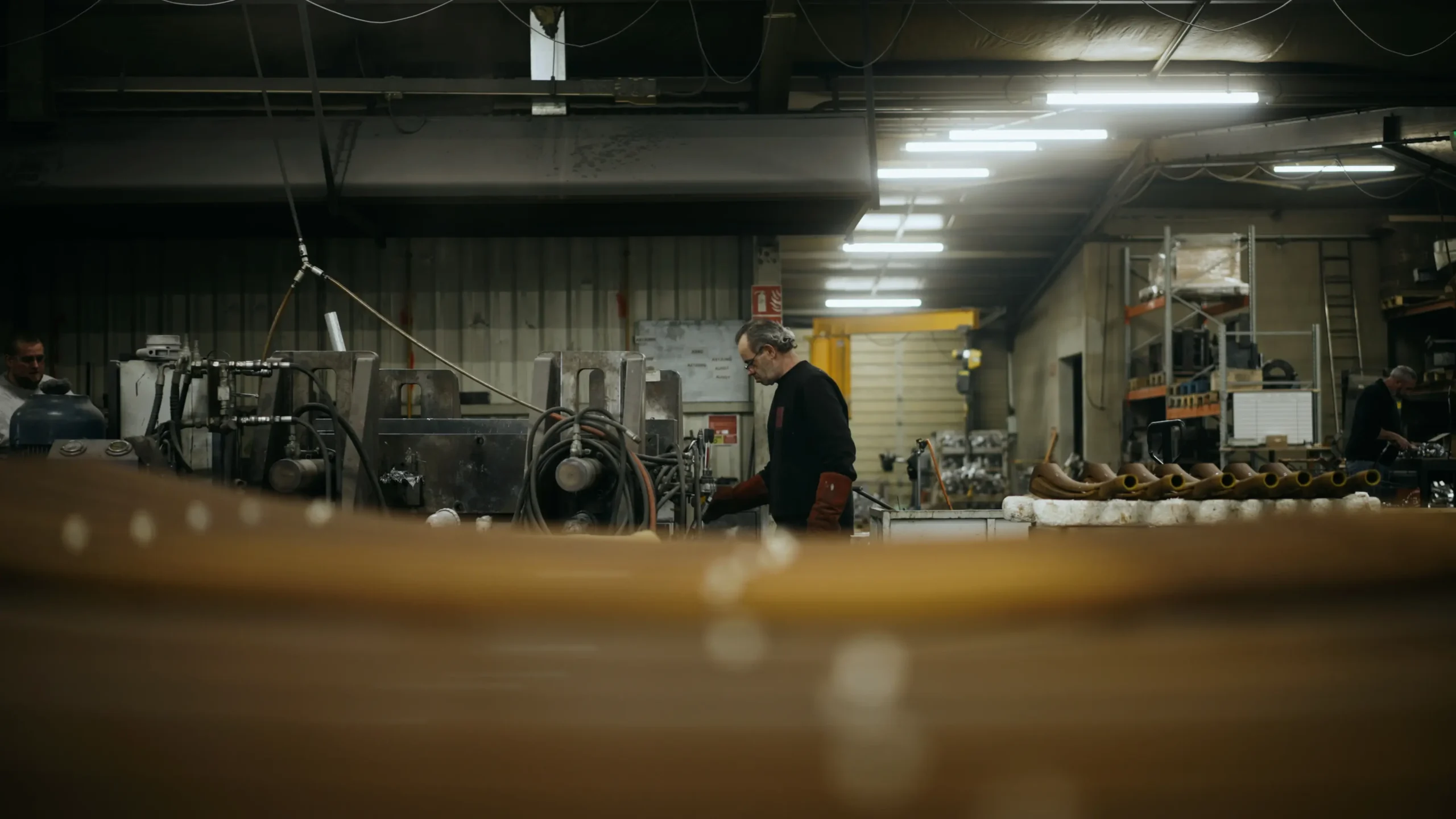 Atelier de fonderie en enfilade, opérateur au travail au fond près des postes de moulage