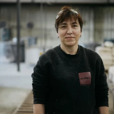 Portrait d'une opératrice de la fonderie posant dans l'atelier de production aluminium