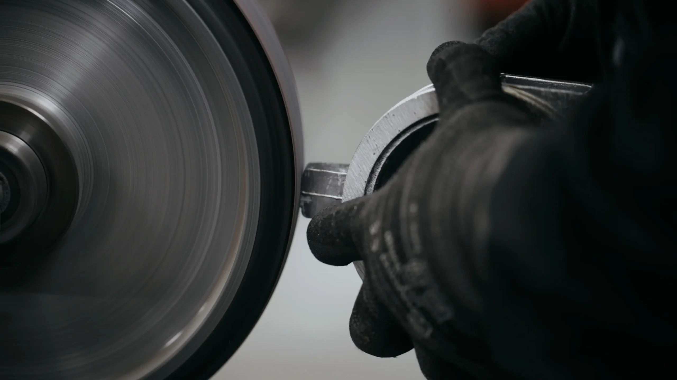 Pièce d'aluminium travaillée sur une meule rotative lors de l'étape de parachèvement