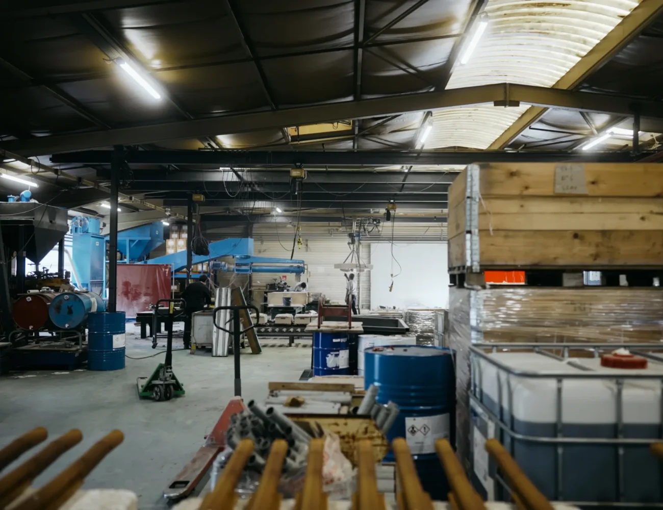 Vue large de l'atelier de fonderie avec ses équipements, cuves et zones de stockage