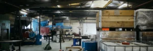 Vue large de l'atelier de fonderie avec ses équipements, cuves et zones de stockage
