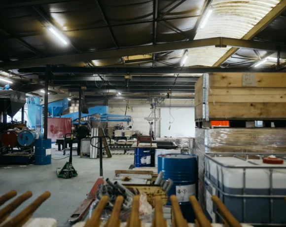 Vue large de l'atelier de fonderie avec ses équipements, cuves et zones de stockage